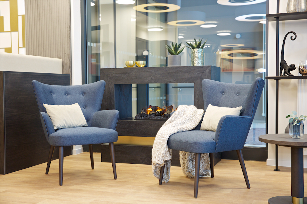 Comfortabele wachtruimte met blauwe stoelen en moderne inrichting, ontworpen voor het welzijn van patiënten in zorginstellingen.